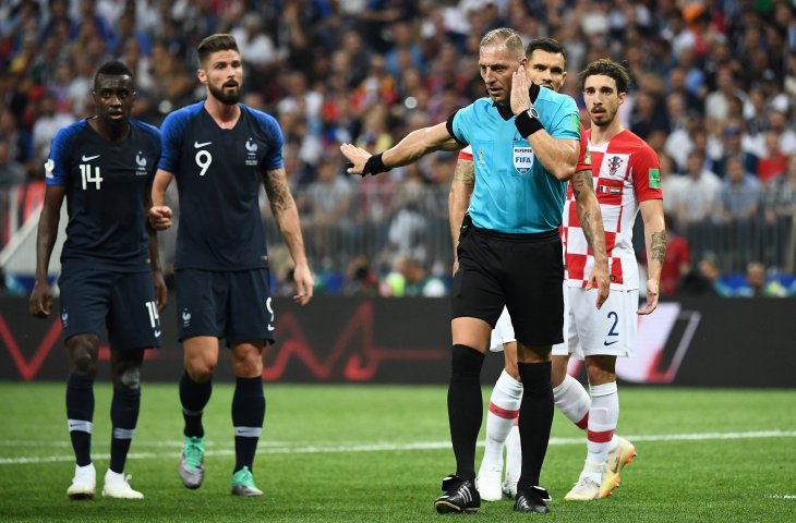 Wasit asal Argentina Nestor Pitana mendengarkan masukan dari wasit Video Assistant Refereeing (VAR) saat final Piala Dunia 2018 antara Prancis vs Kroasia di Luzhniki Stadium, Moscow (AFP)