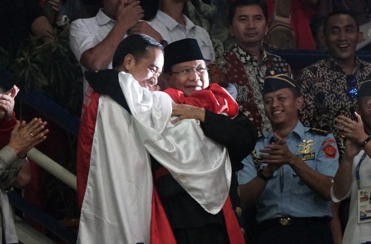 Presiden Joko Widodo (kiri) dan Ketua Umum Pengurus Besar Ikatan Pencak Silat Indonesia (IPSI) Prabowo Subianto (kanan) dipeluk Pesilat Hanifah Yudani Kusumah saat merayakan emas di cabang olahraga Pencak Silat Asian Games 2018 di Padepokan Pencak Silat di Taman Mini Indonesia Indah, Jakarta, Rabu (29/8). (ANTARA FOTO/Kumparan/INASGOC/Aditia Noviansyah)