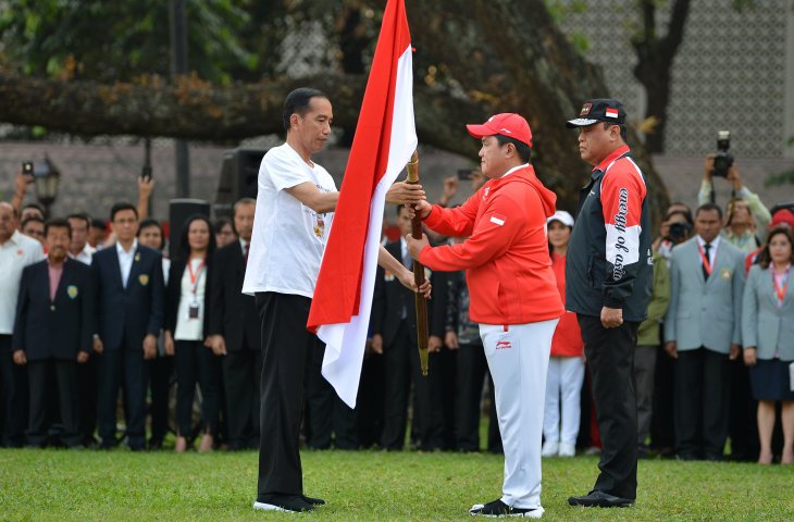 Presiden Joko Widodo (kiri) menyerahkan bendera Merah Putih kepada Ketua Komite Olahraga Indonesia (KOI) Erick Thohir (tengah) disaksikan CdM kontingen Indonesia, Komjen Pol Syafruddin saat upacara pelepasan di halaman tengah Kompleks Istana, Jakarta, Rabu (8/8). Presiden melepas 938 atlet dan 396 ofisial yang akan berlaga pada Asian Games 2018 dengan menargetkan minimal 16 medali emas atau masuk 10 besar. (ANTARA FOTO/Wahyu Putro)