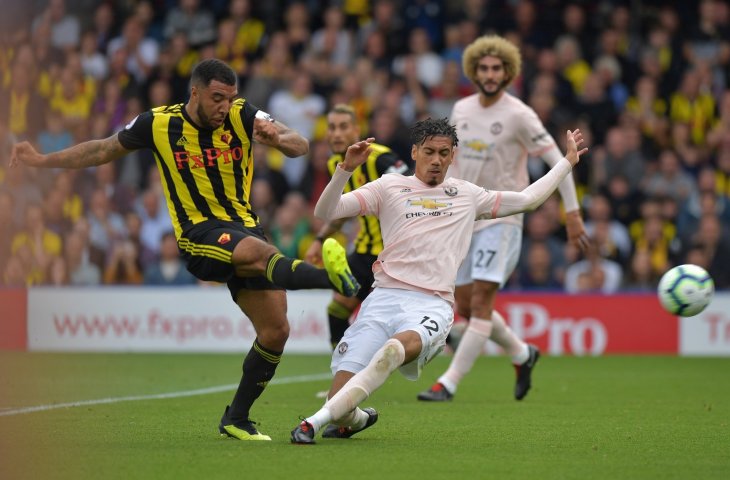 Pemain Watford, Troy Deeney diadang pemain Manchester United, Chris Smalling (AFP)