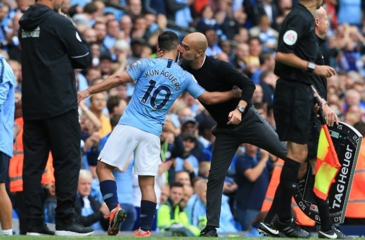 Pelatih Manchester City, Pep Guardiola memeluk Sergio Aguero saat menariknya keluar ketika laga melawan Huddersfield Town pada 19 Agustus 2018 (Lindsey Parnaby/AFP)