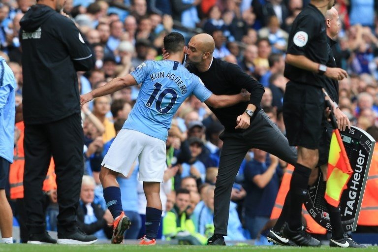 Pelatih Manchester City, Pep Guardiola memeluk Sergio Aguero saat menariknya keluar ketika laga melawan Huddersfield Town pada 19 Agustus 2018 (Lindsey Parnaby/AFP)