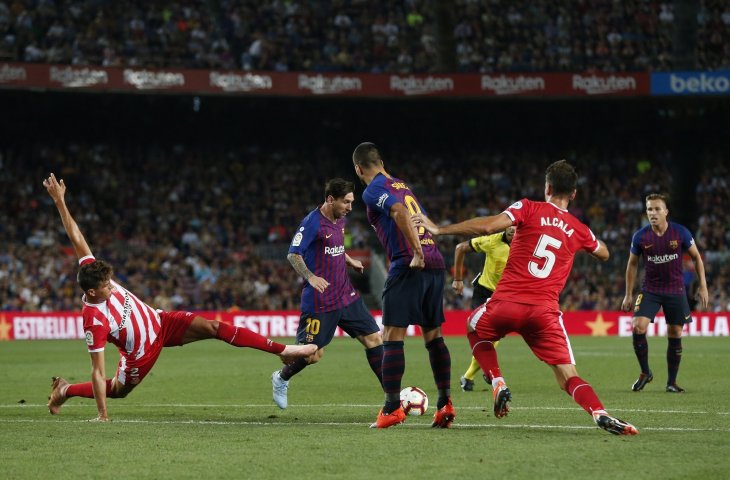 Pemain Girona, Bernardo Espinosa (kiri) melakukan tekel kepada pemain Barcelona, Lionel Messi di Camp Nou Stadium, Barcelona (AFP)