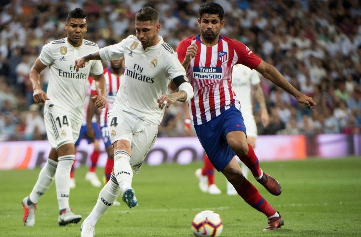 Pemain Real Madrid, Sergio Ramos (kiri) menghalau pemain Atletico Madrid, Diego Costa di Stadion Santiago Bernabeu (AFP)