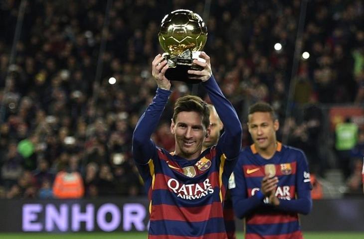 Lionel Messi mengangkat trofi Ballon d'Or di depan para pendukungnya di Camp Nou (Lluis Gene/AFP)