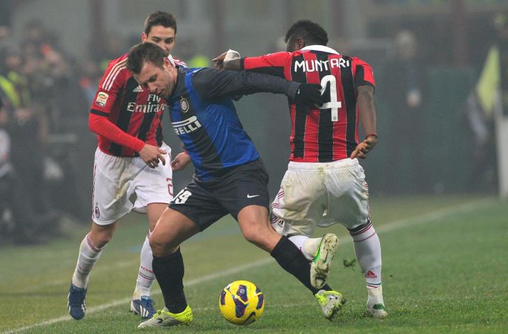 Pemain AC Milan, Ghana Sulley Muntari (kanan) mengadang pemain Inter Milan, Antonio Cassano saat laga Serie A di Stadion San Siro (24/2/2013) (AFP)