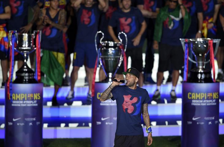 Pemain Barcelona Dani Alves bersama tiga trofi Liga Champions (AFP)