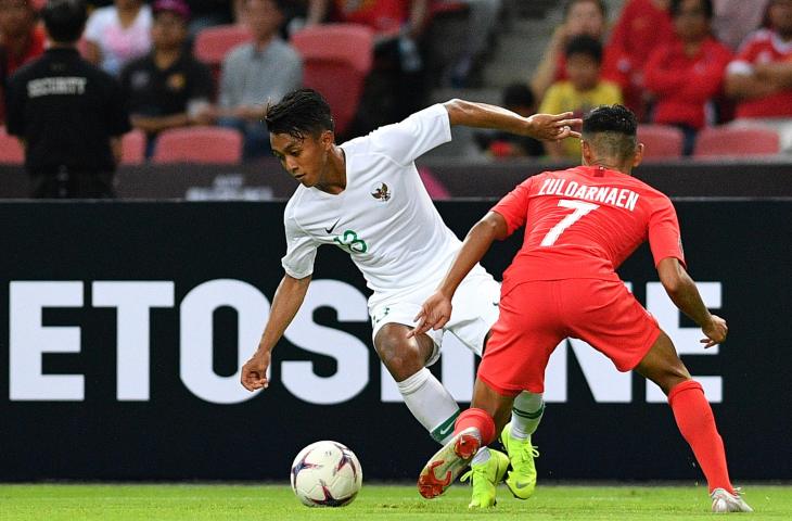 Pemain Timnas Indonesia Febri Hariyadi (kiri) menggiring bola melewati pemain timnas Singapura Muhammad Zulqarnaen Suzliman dalam penyisihan grub B Piala AFF 2018 di Stadion Nasional Singapura, Jumat (9/11/2018). Indonesia kalah 0-1 dalam pertandingan perdana tersebut. (ANTARA FOTO/Sigid Kurniawan)