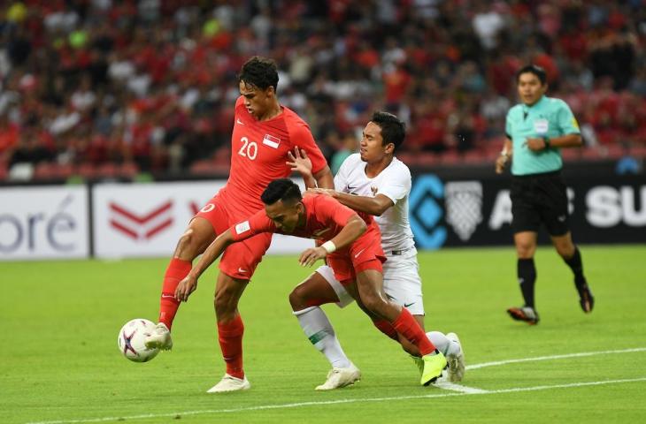 Pemain Timnas Indonesia, Ricky Fajrin menghalau pemain timnas Singapura di matchday 1 grup B Piala AFF 2018, di Stadion Nasional Singapura. (AFF)