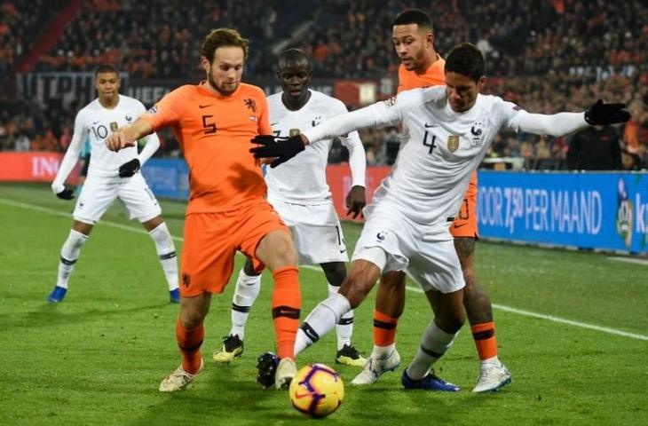 Daley Blind (kiri) dan Raphael Varane (kanan) terlibat dalam duel perebutan bola di ajang UEFA Nations League (John Thys/AFP)