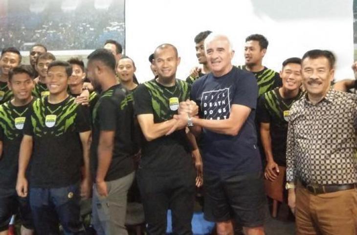 Pemain Persib, Supardi Nasir (kiri) berjabat tangan dengan pelatih Persib Roberto Carlos Mario Gomez (kanan) di Graha Persib, Jalan Sulanjana, Bandung, Jawa Barat, Rabu (21/11/2018). [Suara.com/Aminuddin]