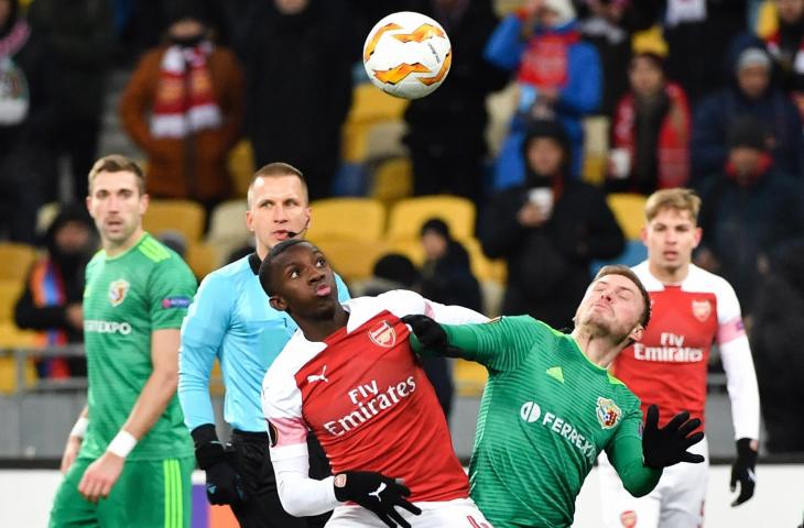 Pemain Vorskla, Oleksandr Skliar duel udara dengan Pemain Arsenal, Eddie Nketiah saat Liga Eropa di Olympiyski Stadium, Kiev, (29/11/2018) 
