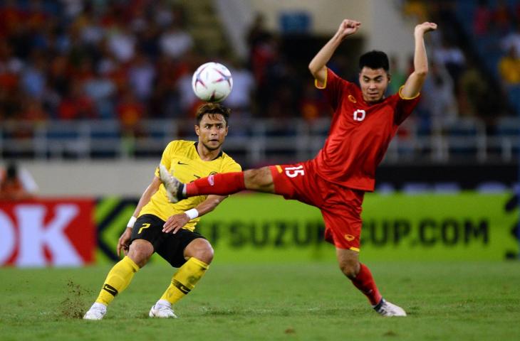 Bek Timnas Malaysia, Aidil Zafuan berebut bola dengan pemain timnas Vietnam, Pham Duc Huy di final leg kedua Piala AFF 2018 di Stadion My Dinh, Vietnam. (AFP)