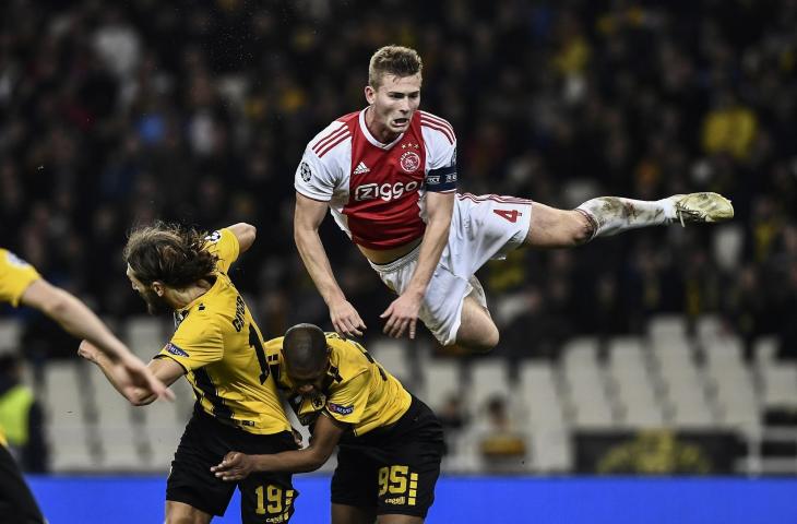 Pemain Ajax, Matthijs de Ligt saat duel udara dengan pemain AEK Athens Alef Saldanha dan Dmytro Chygrynskiy pada pertandingan Liga Champions di Athens Olympic Stadium, Athens, (27/11/2018) (AFP)