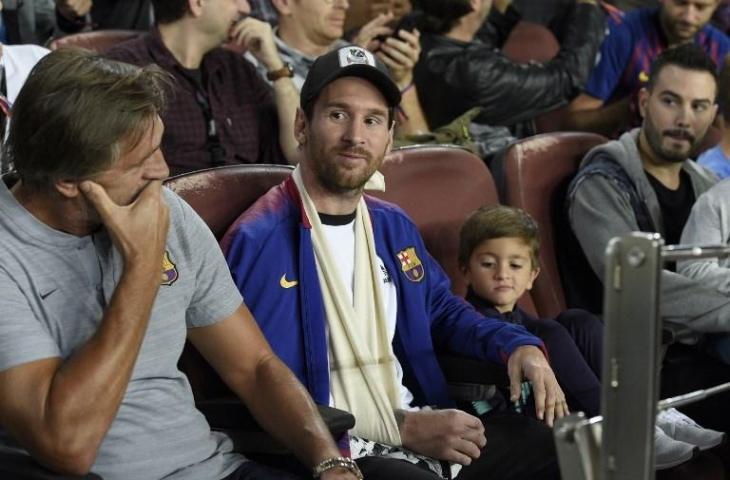 Lionel Messi dan anaknya saat menyaksikan laga Barcelona vs Inter Milan di Liga Champions pada 24 Oktober 2018 (Lluis Gene/AFP)