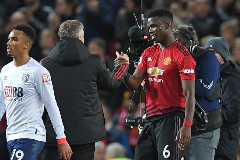 Gelandang Manchester United, Paul Pogba berjabatan tangan dengan Ole Gunnar Solskjaer usai pertandingan melawan Bounemouth pada 30 Desember 2019 (Paul Ellis/AFP)