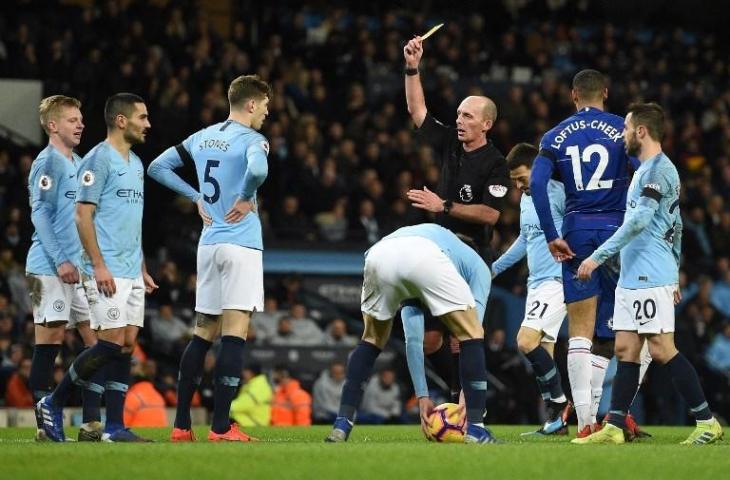 Wasit Mike Dean saat memberikan kartu kuning kepada Ilkay Gundogan pada laga melawan Chelsea (10/2/2019) [Oli/Scarff/AFP]