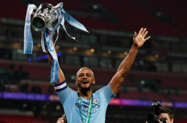 Bek Manchester City, Vincent Kompany memegang trofi Piala Liga Inggris. (Adrian Dennis/AFP)