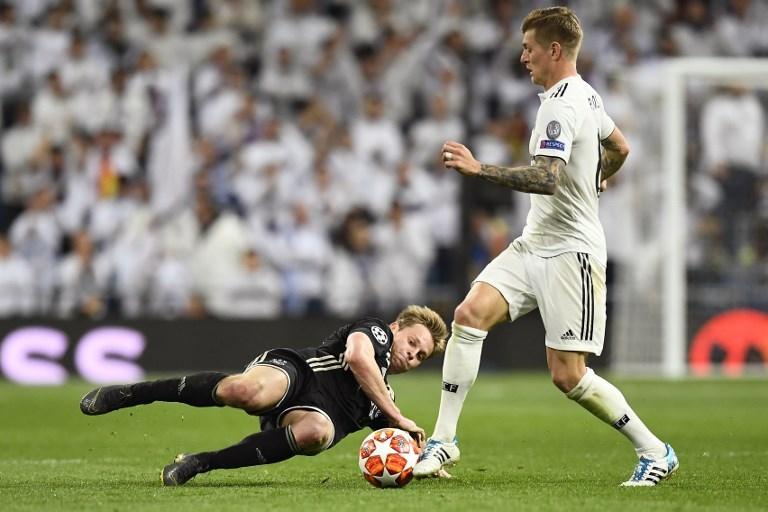 Gelandang Ajax Amsterdam, Frenkie de Jong melepaskan tekel kepada Toni Kroos pada laga melawan Real Madrid di Liga Champions pada 5 Maret 2019 (Gabriel Bouys/AFP)