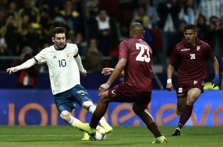 Aksi Lionel Messi melewati pemain Venezuela saat laga uji coba Internasional pada 22 Maret 2019 (Benjamin Cremel/AFP)