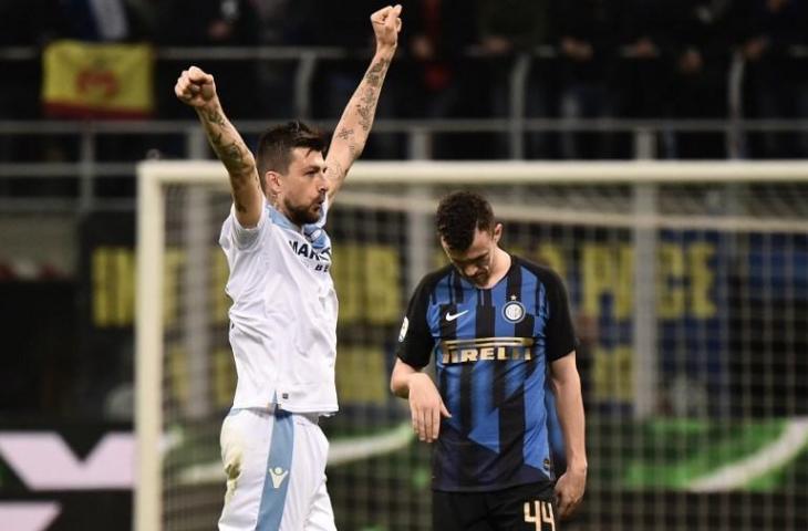 Ekspresi Francesco Acerbi merayakan kemenangan di depan pemain Inter Milan Ivan Perisic. Lazio berhasil mencuri tiga poin di kandang Inter usai menang 1-0. [Marco BERTORELLO / AFP]