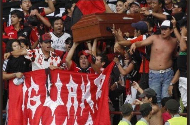 Kelompok ultras dari tim di Liga Kolombia membawa jasad seorang suporter dalam peti jenazah ke dalam stadion (twitter.com/Geordioca)