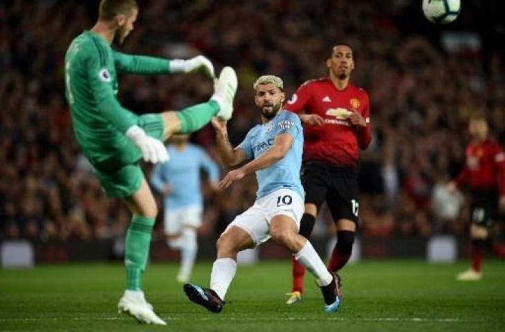 Aksi kiper Manchester United, David de Gea saat berhasil menghalau serangan Manchester City yang dikomandoi Sergio Aguero pada lanjutan pertandingan Liga Primer Inggris di Old Trafford, Kamis (25/4/2019) dini hari WIB. (OLI SCARFF / AFP)