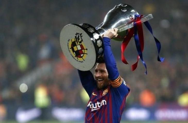 Striker Lionel Messi mengangkat trofi juara La Liga 2018/2019. (PAU BARRENA / AFP)
