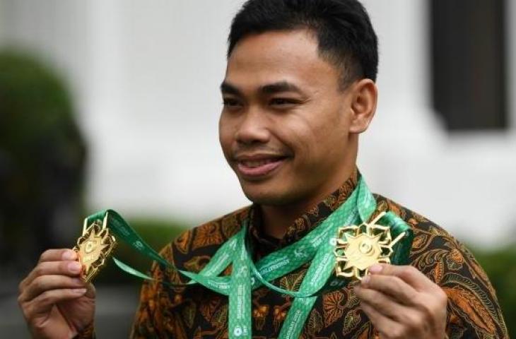 Lifter Eko Yuli Irawan memperlihatkan medali emas yang diraihnya pada Kejuaraan Dunia Angkat Besi 2018 seusai diterima oleh Presiden Joko Widodo di Kompleks Istana Kepresidenan, Jakarta, Kamis (8/11). [Antara/Wahyu Putro A]