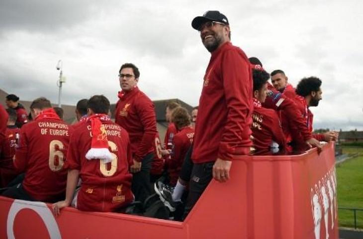 Manajer Liverpool, Jurgen Klopp (tengah) bersama para pemainnya dari atas bus terbuka melihat sambutan ribuan para pendukung Liverpool saat parade memamerkan trofi Juara Liga Champions. (Oli SCARFF / AFP)