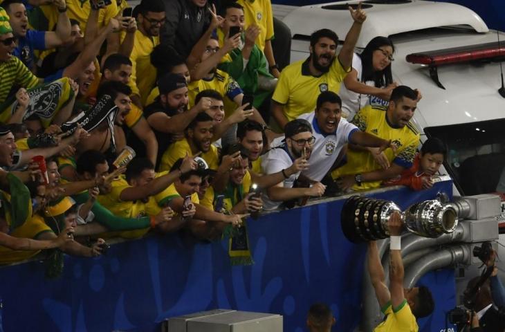 Pemain Brasil, Thiago Silva merayakan keberhasilan Brasil jadi juara Copa America 2019 bersama para pendukungnya, Senin (8/7/2019). Brasil memastikan diri sebagai juara Copa America 2019 usai menundukkan Peru di partai final 3-1. [MAURO PIMENTEL / AFP]