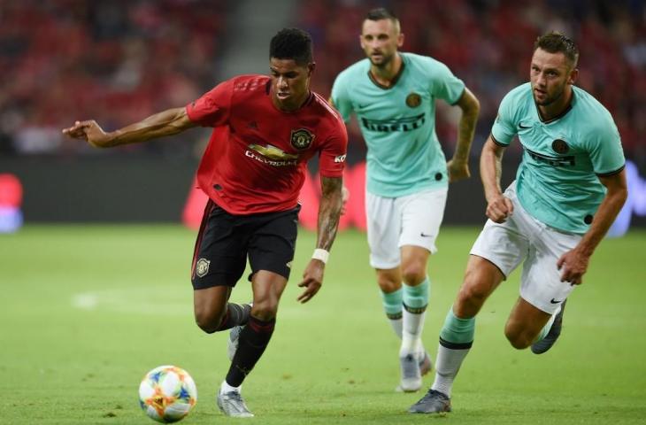 Pemain Manchester United, Marcus Rasford berebut bola dengan pemain Inter Milan Stevan de Vrij dalam laga ICC beberapa waktu lalu. Jersey Inter Milan berwarna biru toska ini punya desain yang serupa dengan jersey Real Madrid. [ROSLAN RAHMAN / AFP] 