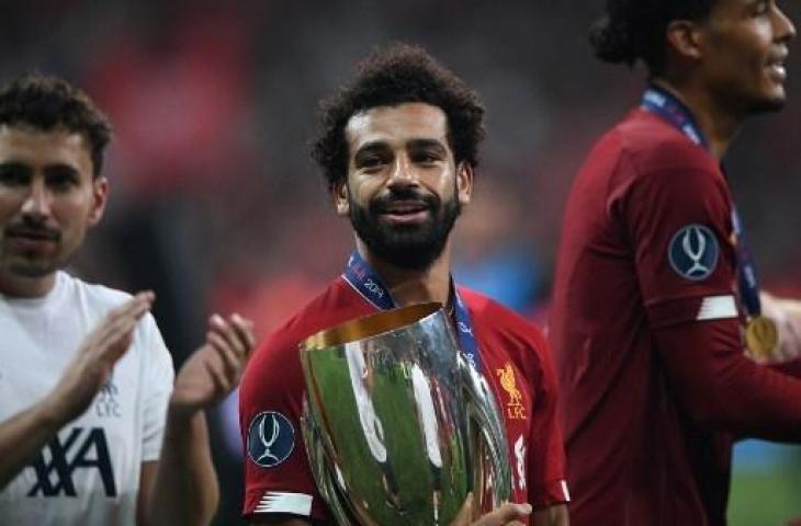 Mohamed Salah dan trofi Piala Super Eropa 2019. (BULENT KILIC / AFP)