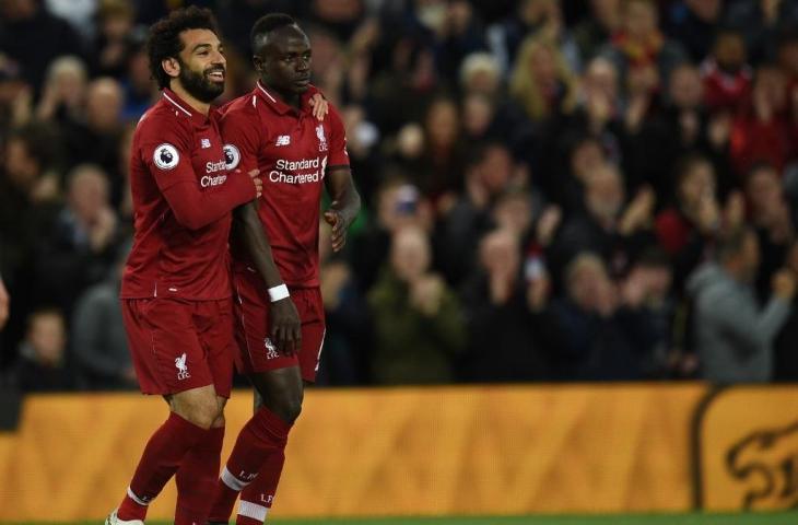 Dua penyerang Liverpool, Mohamed Salah dan Sadio Mane berangkulan. (OLI SCARFF / AFP)