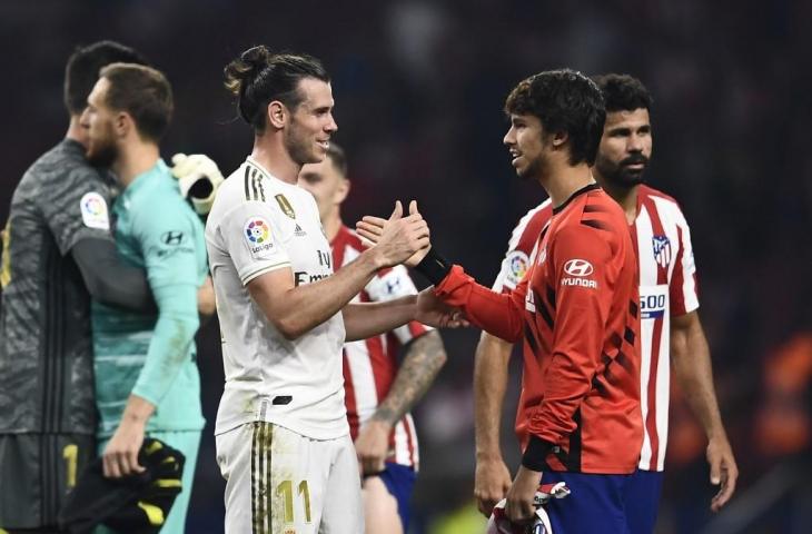 Gareth Bale tampak bersalaman dengan Joao Felix usai laga derby Madrid. Laga tersebut berakhir imbang tanpa gol, Minggu (29/9/2019). [OSCAR DEL POZO / AFP]