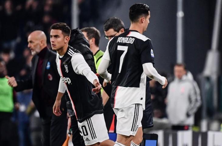 Cristiano Ronaldo tampak bersalaman dengan Paulo Dybala seusai ditarik keluar oleh Maurizio Sarri di laga Juventus kontra AC Milan, Senin (11/11/2019) dini hari tadi. [MARCO BERTORELLO / AFP]