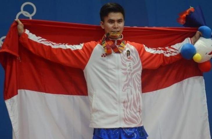 Atlet wushu Indonesia Edgar Xavier Marvelo menggigit medali setelah memenangi nomor gunshu putra SEA Games 2019 di gedung World Trade Center Manila, Filipina, Selasa (3/12). [Antara/Nyoman Budhiana]