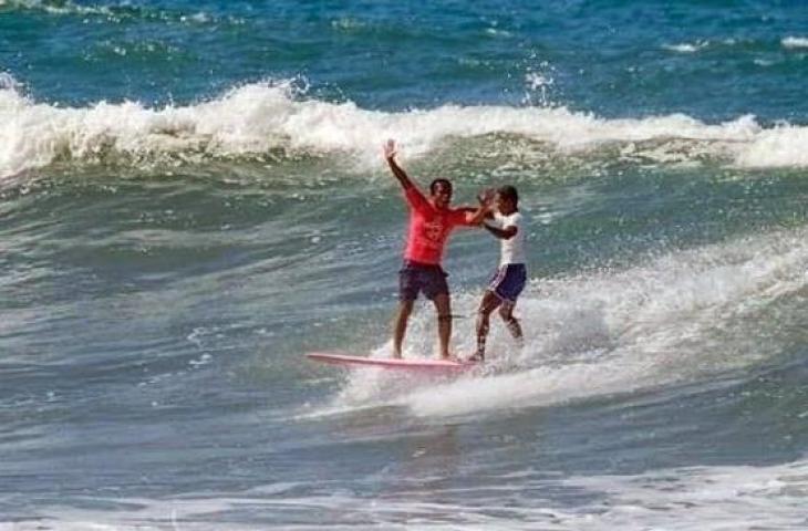 Peselancar Filipina, Roger Casugay menolong atlet Indonesia, Arip Hidayat, yang tergulung ombak besar pada pertandingan cabang olahraga selancar nomor longboard putra SEA Games 2019 di Pantai Monaliza, La Union, Subic, Filipina pada, Jumat (6/12/). [Facebook/Jefferson Ganuelas]