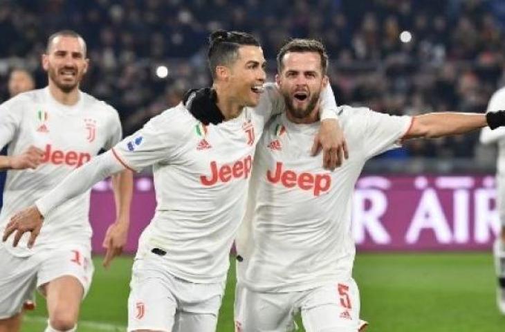 Bintang Juventus Cristiano Ronaldo merayakan golnya ke gawang AS Roma dari titik penalti bersama Miralem Pjanic saat laga Liga Italia di Olympico stadium. (Tiziana FABI / AFP)