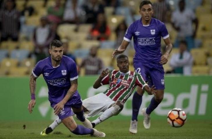 Calon pemain Arema FC, Santiago Carrera (kiri bawah) saat membela Defensor Sporting di Liga Uruguay. (PABLO PORCIUNCULA / AFP)