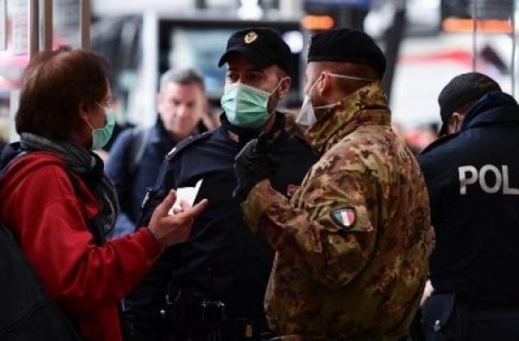 Polisi dan tentara melakukan penjagaan di setiap akses masuk atau keluar kota Milan yang diisolasi menyusul penyebaran virus corona, Minggu (9/3/2020). [AFP]