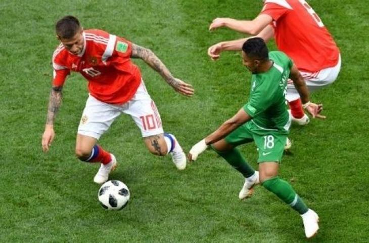 Pemain Rusia, Fedor Smolov berebut bola dengan pemain Arab Saudi Salem Al-Dawsari di laga perdana Grup A Piala Dunia 2018, Kamis (14/6/2018) [AFP]