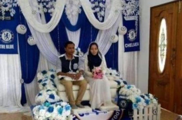 Pasangan penganting nikah pakai atribut Chelsea. (Twitter.com/alexasaffira)