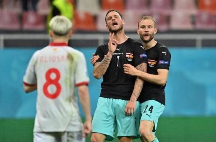 Penyerang Austria, Marko Arnautovic melakukan selebrasi provokatif usai membobol gawang Makedonia Utara dalam ajang Euro 2020. (DANIEL MIHAILESCU / POOL / AFP)