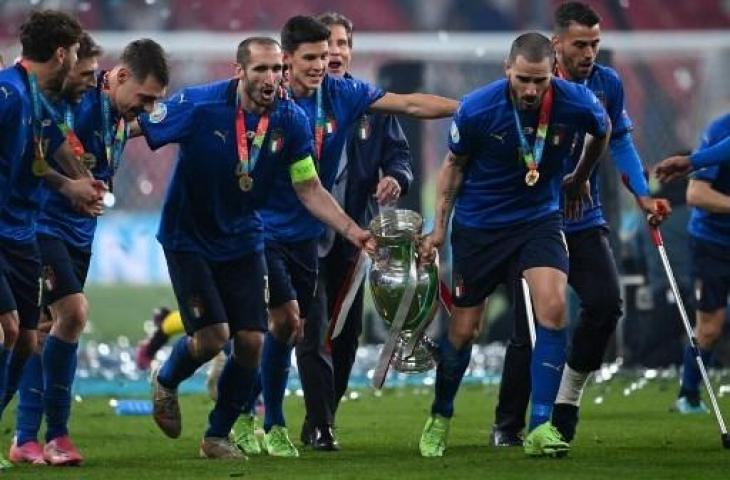 Dua bek Timnas Italia, Giorgio Chiellini dan Leonardo Bonucci mengangkat trofi Euro 2020. (ANDY RAIN / POOL / AFP)