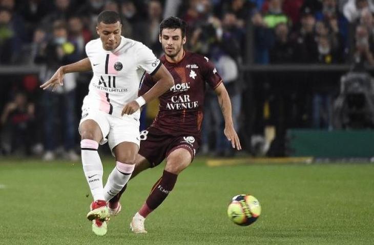 Pemain PSG, Kyliann Mbappe dihadang pemain Metz Febien Centonze dalam laga lanjutan Bundesliga, Kamis (23/9/2021). (AFP/Jean-Christoper Verhaegen)