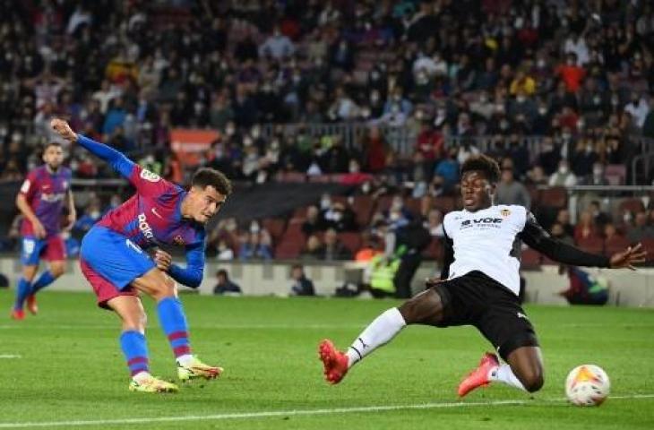 Aksi pemain pengganti Barcelona Philippe Coutinho saat mencetak gol ke gawang Valencia di laga lanjutan La Liga Spanyol di Stadion Camp Nou, Senin (18/10/2021) dini hari WIB. (LLUIS GENE / AFP)