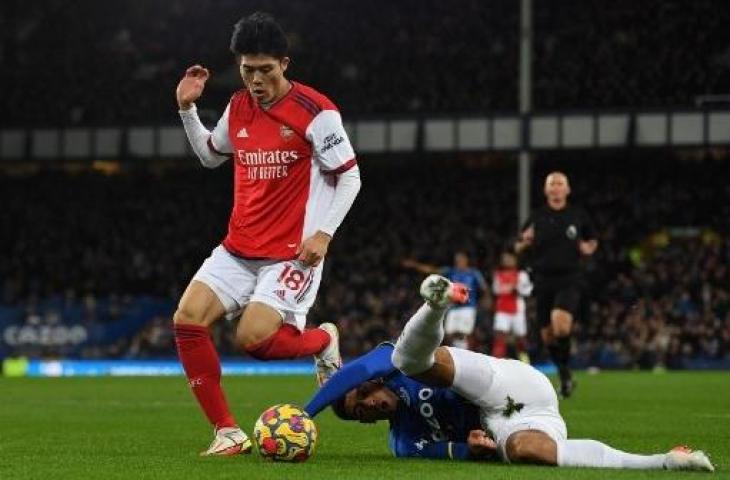 Momen pemain Arsenal, Takehiro Tomiyasu keinjak Ben Godfrey. (Paul ELLIS / AFP)