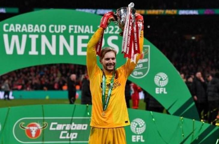 Kiper Liverpool, Caoimhin Kelleher saat mengangkat trofi juara Piala Liga Inggris. (JUSTIN TALLIS / AFP)