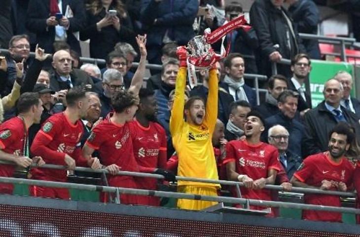 Kiper Liverpool, Caoimhin Kelleher saat mengangkat trofi juara Piala Liga Inggris. (JUSTIN TALLIS / AFP)